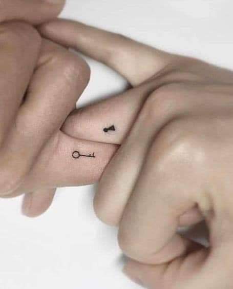 Kleine Tattoos für Paare mit Schlüssel und Schloss an den Fingern