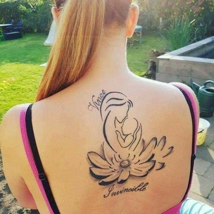 Really Beautiful Tattoos Women on the back flower the word Vice image of mother with baby and the word Invincible Invincible