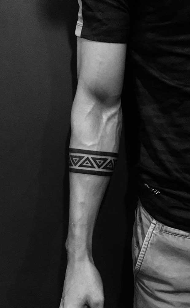 Stammes-Tätowierungen, Streifen oder Armband auf dem Unterarm eines Mannes