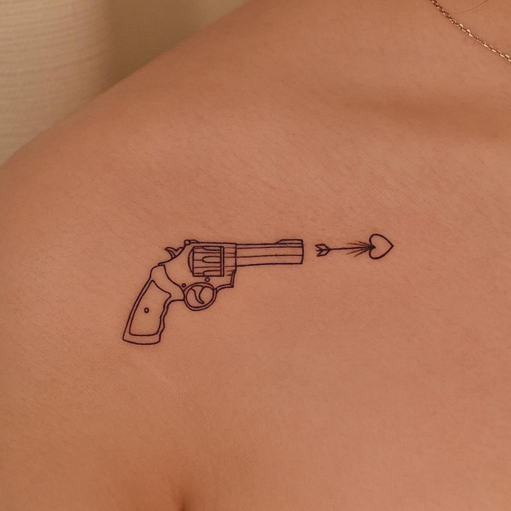 Tatuaggi estetici Bellissimi piccoli tatuaggi minimalisti con muxo Zoom revolver che spara freccia d'amore