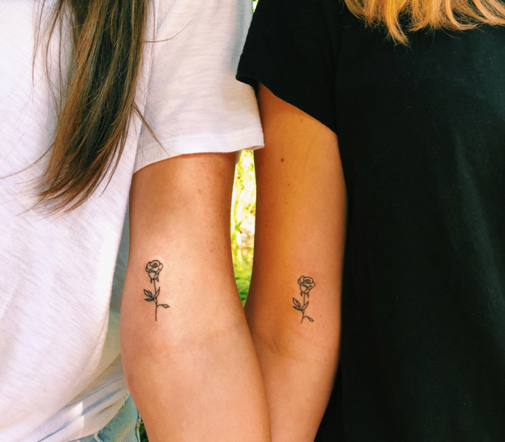 Tatuajes aesthetic super minimalistas dos rosas emparejadas en dos amigas en el brazo