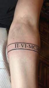 Tatuajes con Letras Romanas a modo de cinta en brazo