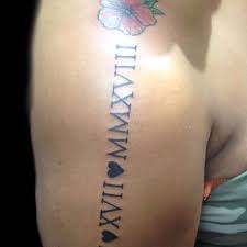 Tatuajes con Letras Romanas en brazo y flor en el hombro