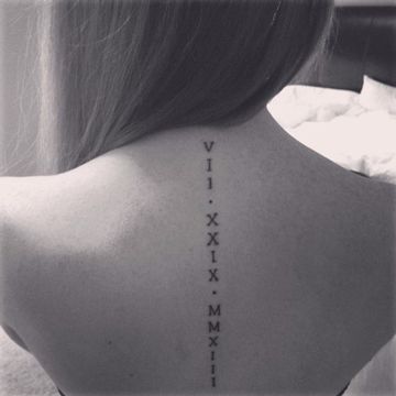 Tatuajes con Letras Romanas vertical encima de la columna mujer