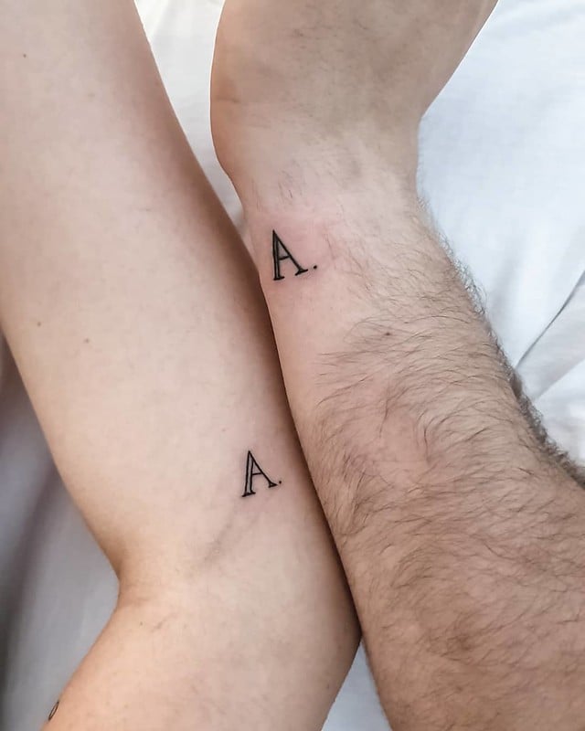 Tattoos with the letter A in couples in arms