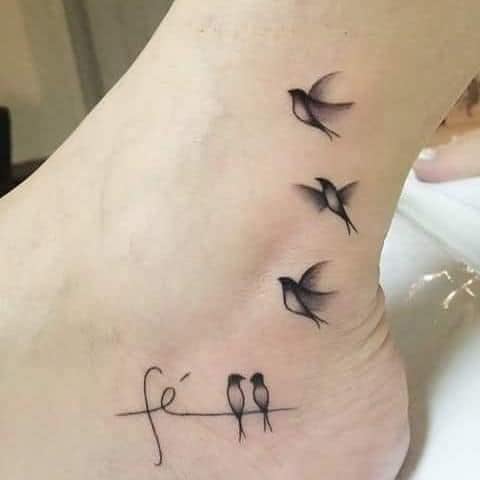 Tatuagens de pássaros no pé com a palavra fé e família de pássaros