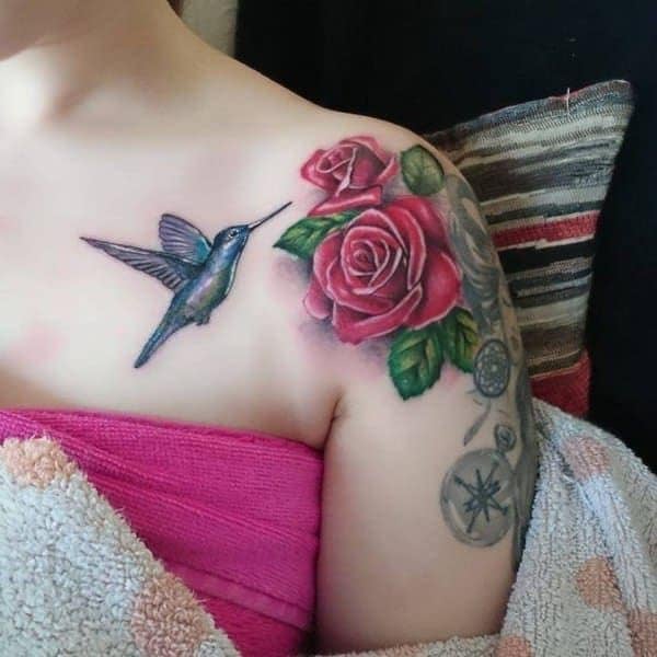 Tätowierungen einer Kolibris-Frau mit roten Rosen auf der Schulter