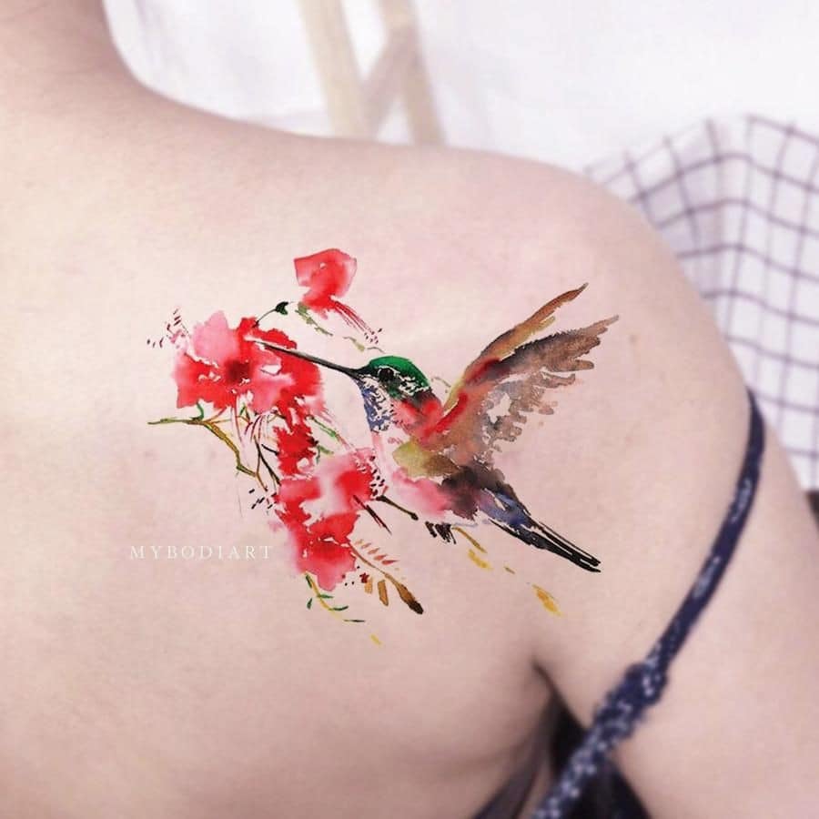 Tatuajes de Colibries Mujer picando flor intensamente roja en hombro