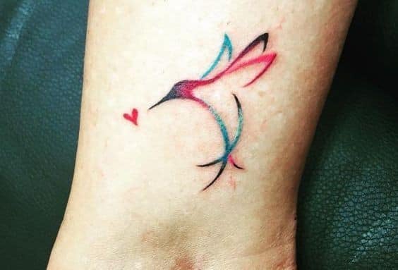 Tatuajes de Colibries Mujer picando un corazon pequeno en muneca contorno