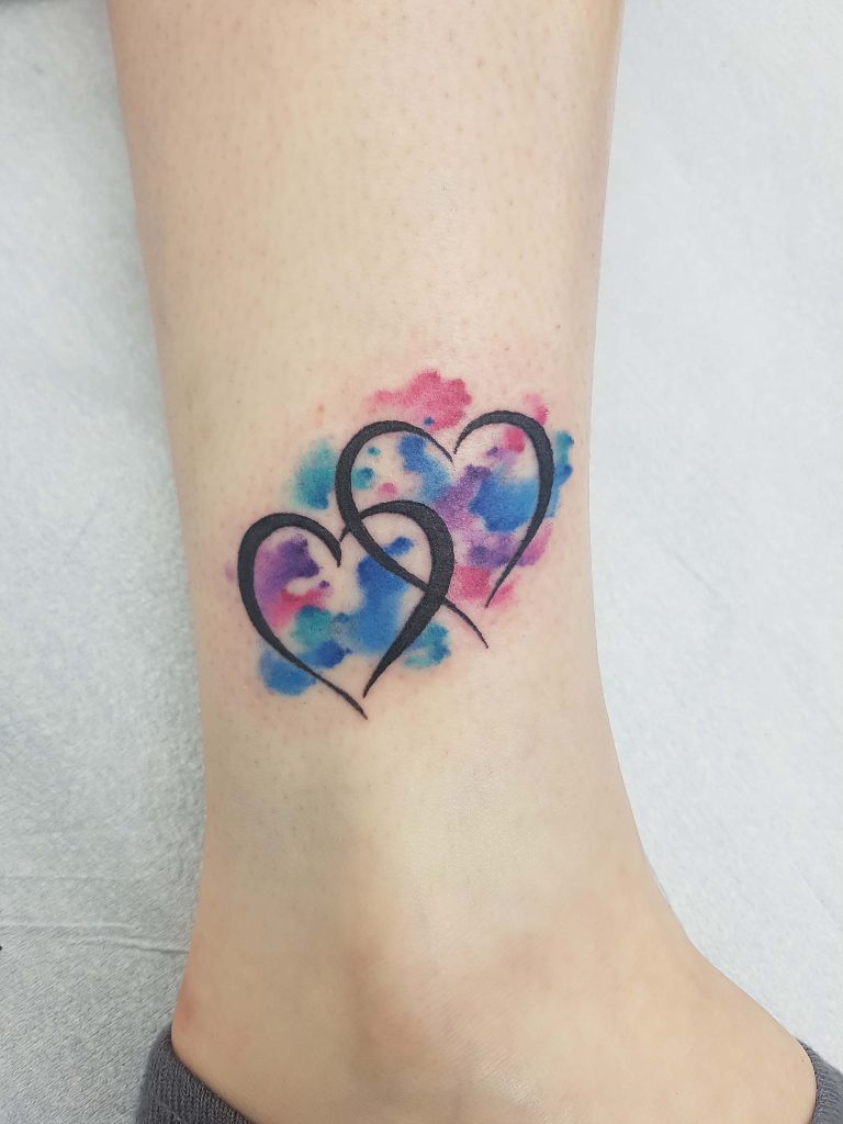 Tatuajes de Corazon Dos corazones acuarelados en pantorrilla