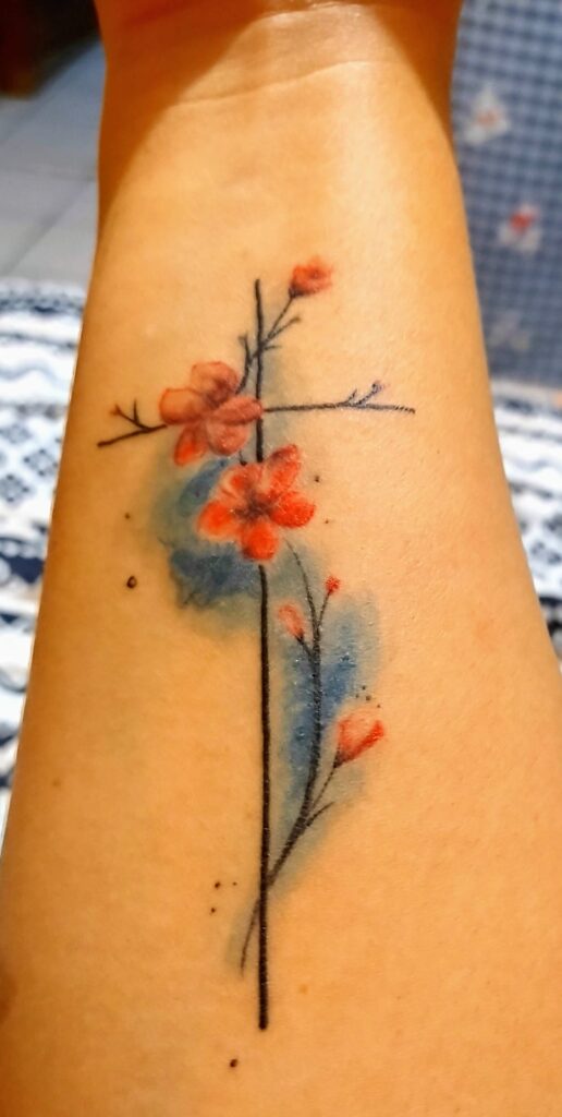 Tatuagens de Cruzes com detalhes azuis no antebraço