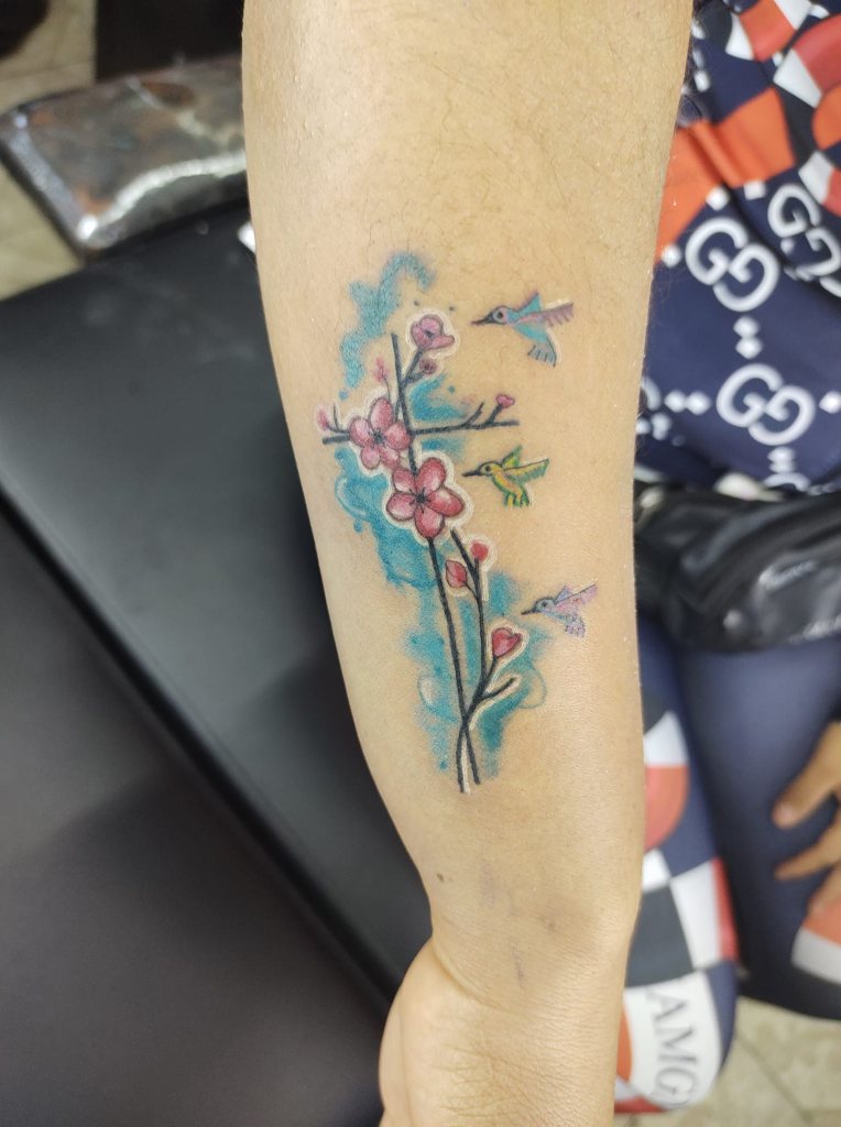 ピンクの花と 3 羽のハチドリの十字のタトゥー