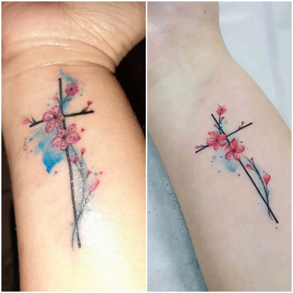 Tatouages de croix au poignet avec des détails bleus