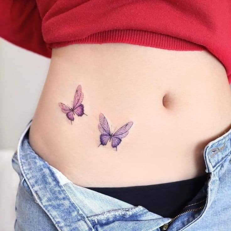 Tatuaggi di farfalle delicate Due farfalle blu violacee sul lato della pancia