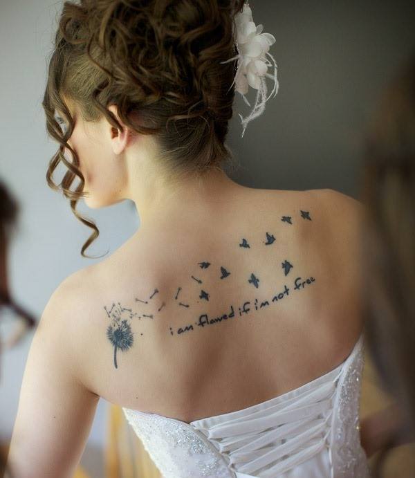 Dandelion tattoos on back with inscription i am fawed if im not free