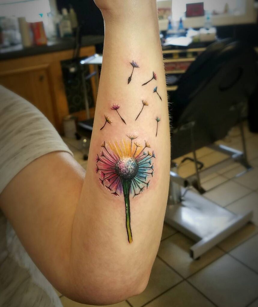 Large colorful celestial purple yellow dandelion tattoos on forearm