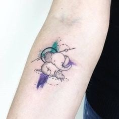 Tatuajes de Elefantes elefantito con circulos lineas y colores verde y violeta en antebrazo