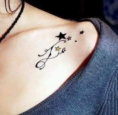 Tatuagens de estrela com o nome Lia no ombro e clavícula