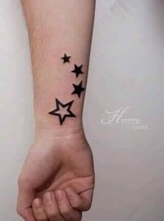 Tatouages quatre étoiles sur le poignet et l'avant-bras