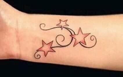 Star tattoos in red colors and ornaments on the wrist