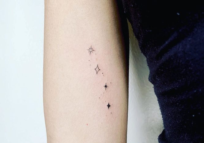 Tatuagens de estrelinhas no braço preto e sem preenchimento