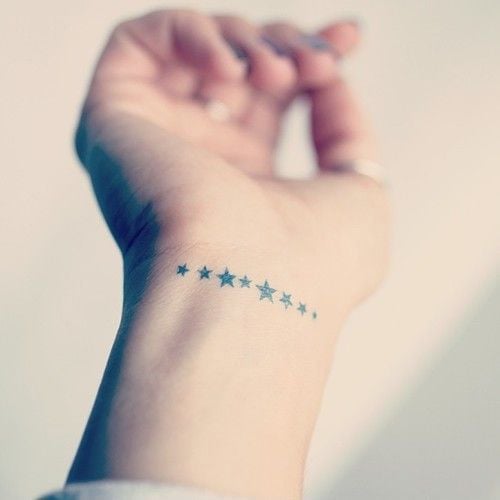 Star tatoue une ligne d'étoiles sur le poignet
