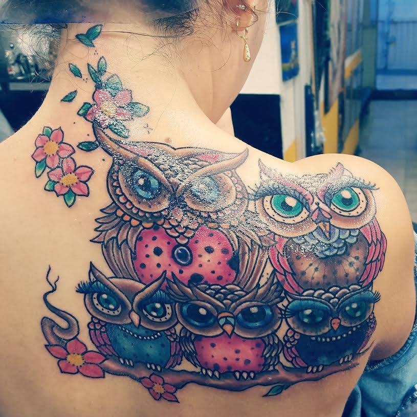 Tatuaggi familiari di bellissimi gufi a colori sulla schiena e sul collo con grandi fiori, madre, padre e tre piccoli gufi