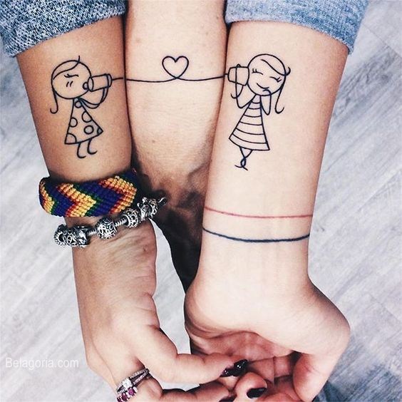 Tatuaggi familiari: tre polsi, due ragazze collegate da un figlio e due lattine all'estremità dei polsi
