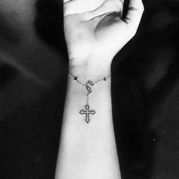 Tätowierungen des Glaubens und der Kreuze. Frauenwort „Glaube“ am Handgelenk
