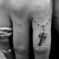 Tatuagens de Fé e Cruzes no dedo indicador com rosário