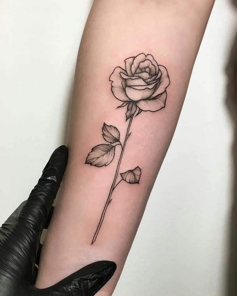 Modello di rosa di schizzo di tatuaggi di fiori neri sull'avambraccio