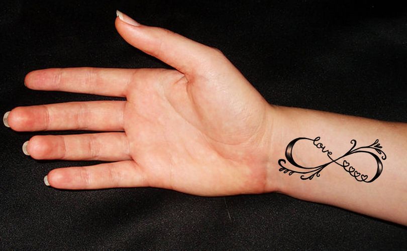 Unendlichkeits-Tattoos mit Quasten und Liebesinschrift am Handgelenk