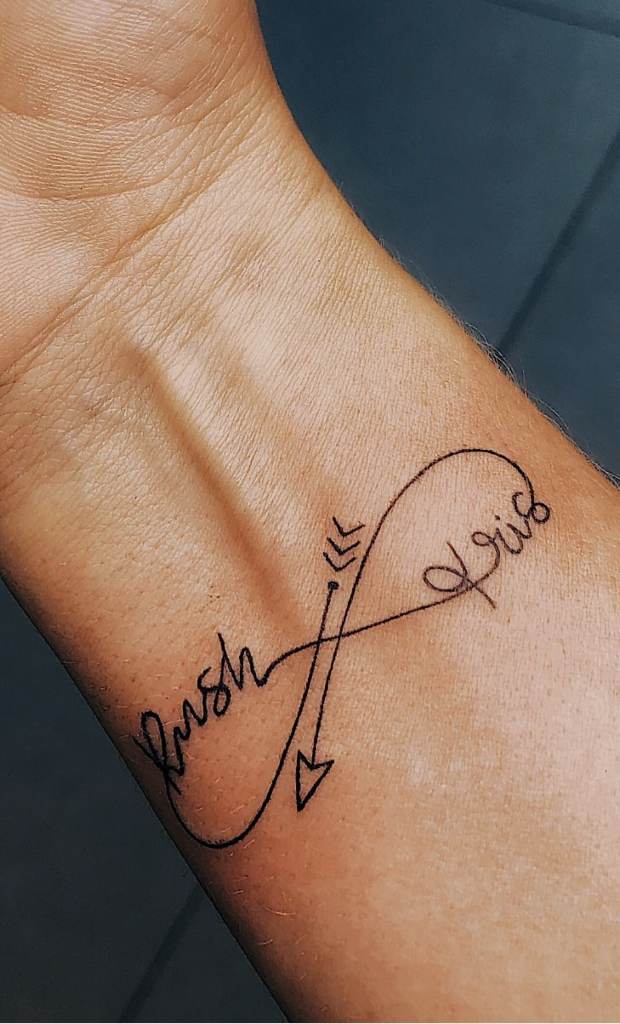 Tatuagens do infinito com flecha e dois nomes Rush e Iris no pulso