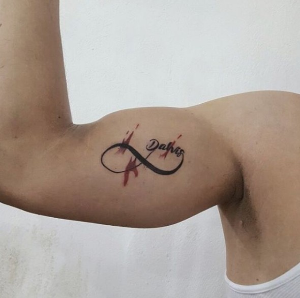 Tatuagens de infinito no braço com nome e toque de aquarela Dabis