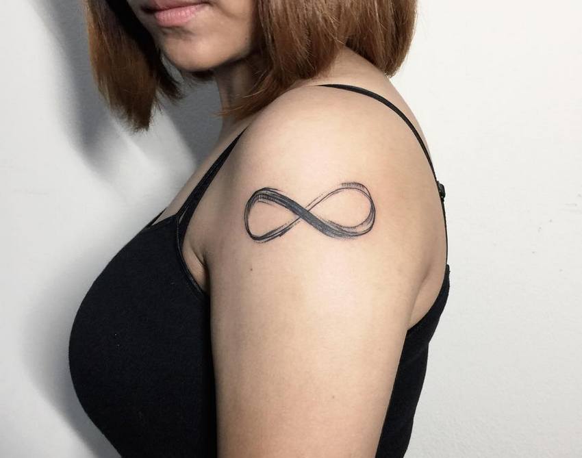 Unendlichkeits-Tattoos auf dem Arm, gemalt im Pinselstil mit unterbrochener Linie