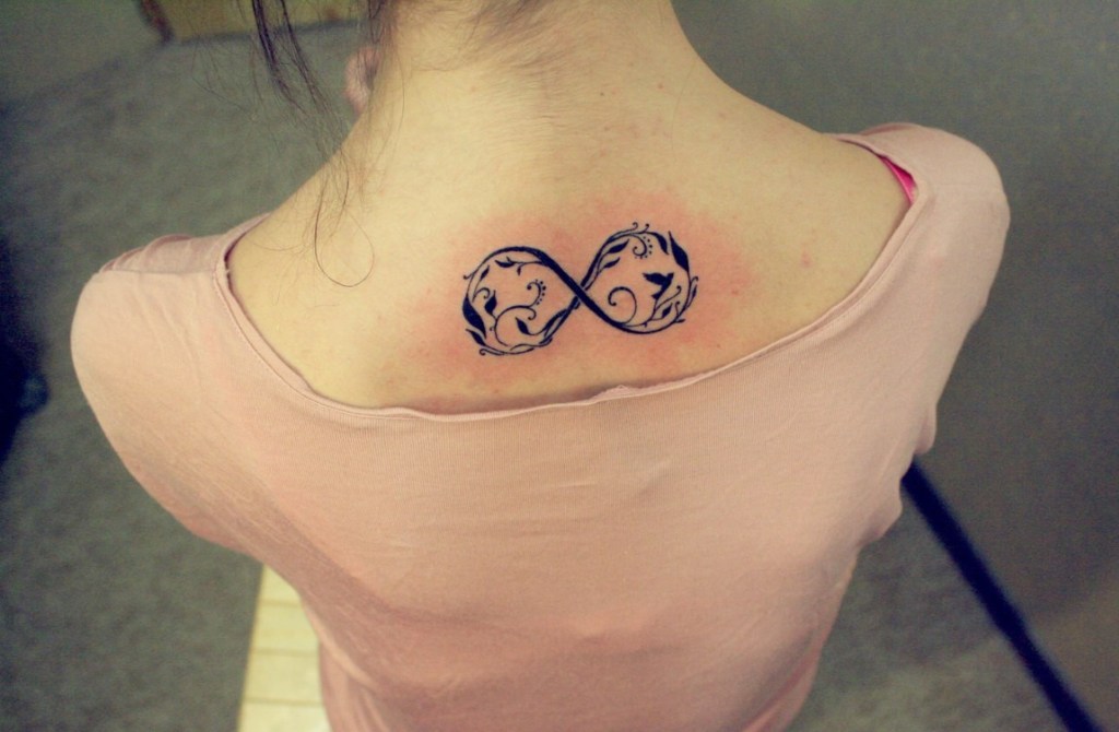Infinity-Tattoos auf dem Rücken einer Frau mit Ornamenten