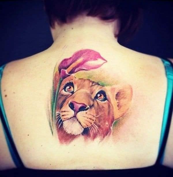 Tatuaggi di leoni sulla schiena tra le scapole, cucciolo di leone che guarda in alto