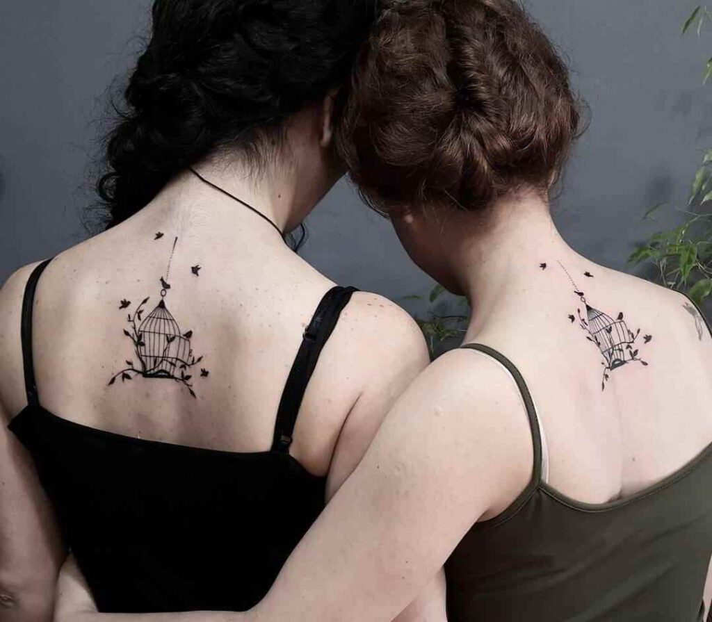 Tatuajes de Madre e Hijas Dos Jaulas con pajaros libres debajo del cuello en espalda
