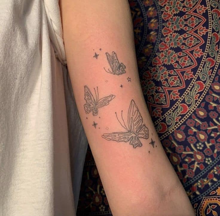 Papillon tatoue trois papillons sur le contour du bras