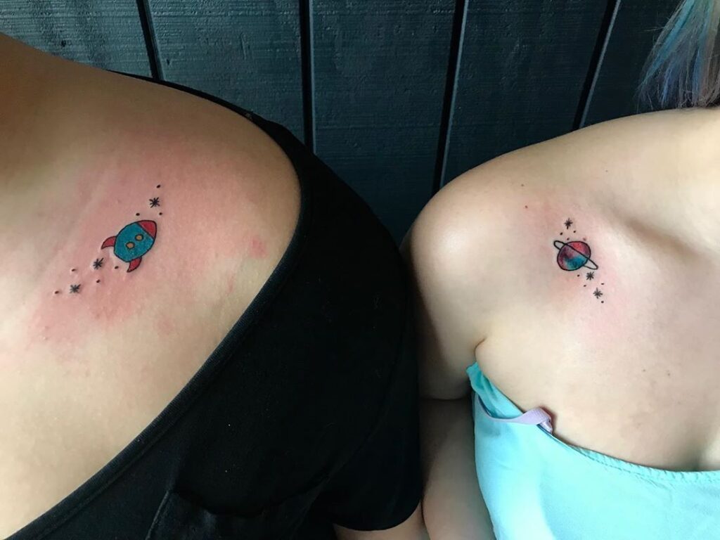 Combinar tatuagens para amigos casais irmãs foguete e saturno em cores em ambas as clavículas