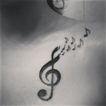 Music tattoos Black treble clef and musical notes to the shoulder