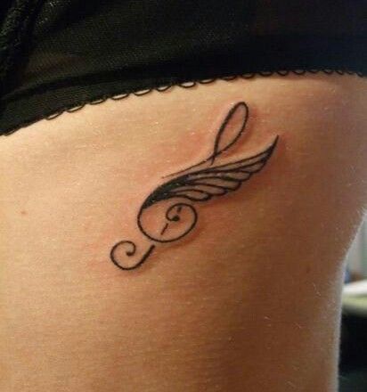Music tattoos Treble clef and wings on ribs