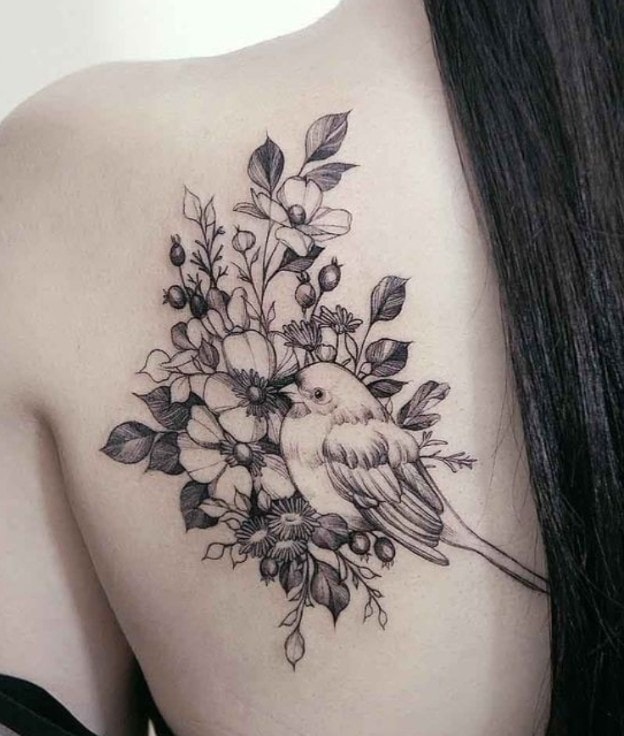 Tatuagens de pássaros e flores na omoplata