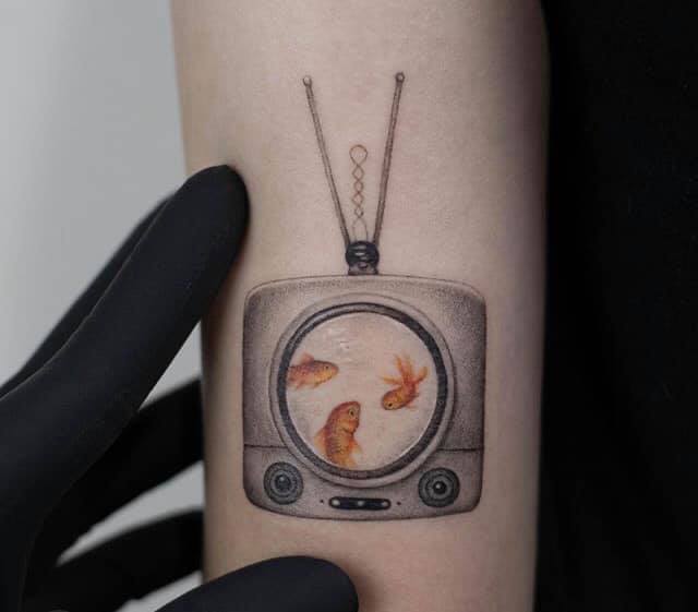 Tatuaggi di pesci sulla piccola televisione 3 pesci arancioni
