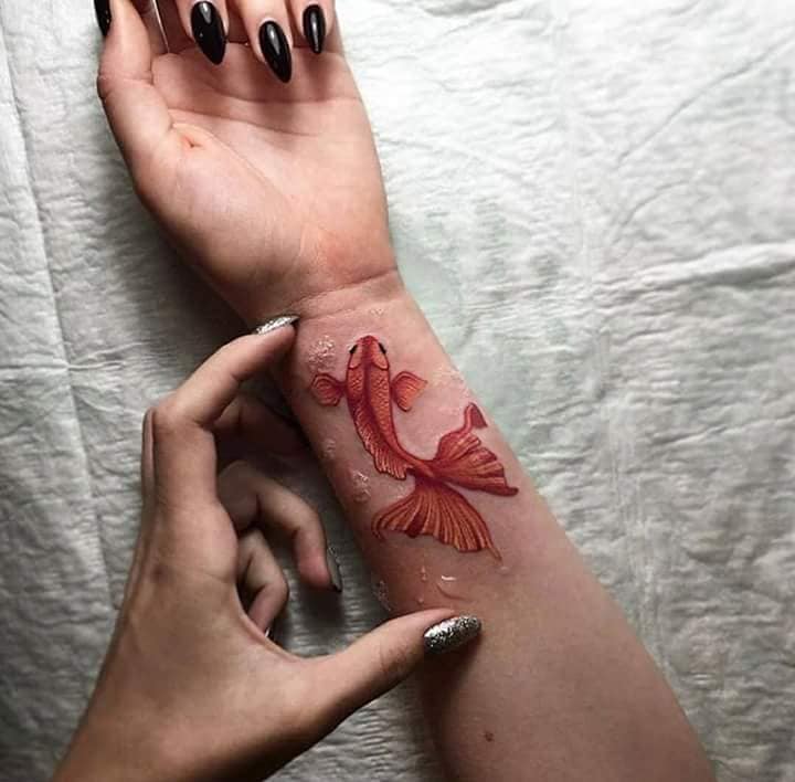 Tatuagem de peixe koi vermelho no pulso