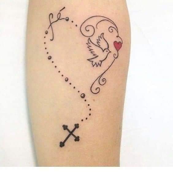 Tattoos von Rosenkränzen, Glaube, Herz, das Wort Glaube, Taube und Kreuz auf dem Unterarm