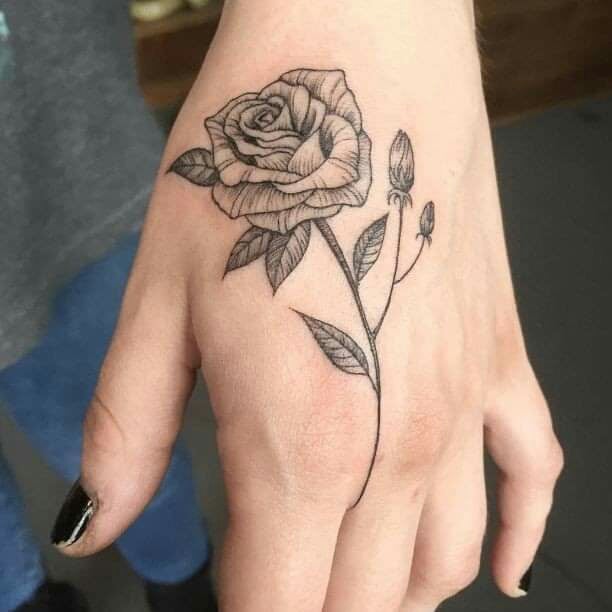 Tatuagens de rosas negras nas mãos acima da mão