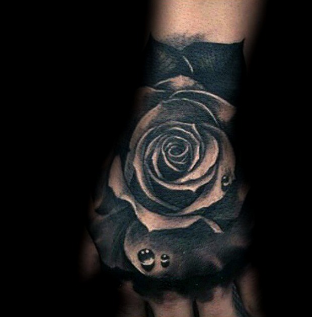 Tatuaggi di rose nere sulle mani in parola nera con gocce di rugiada su tutta la mano