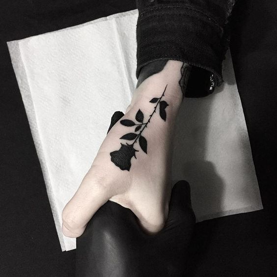 Tatouages de roses noires sur les mains du côté des mots noirs de la main