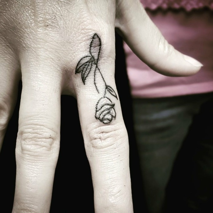 Tatuagens de rosas negras nas mãos no dedo indicador